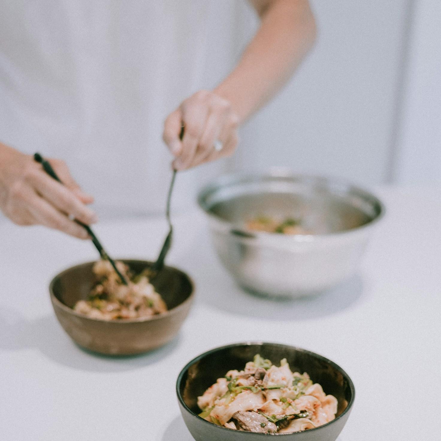 People collaborating in a contemporary kitchen space, exchanging recipes and cooking techniques